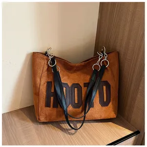 Brown suede tote bag with black leather straps and metal rings, spacious daily commuter bag.