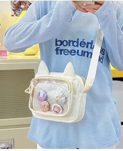 Clear detail shot of the white cat ear ita bag with transparent front pocket and pins.