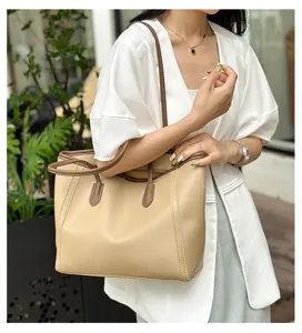 Detail shot of stylish beige and brown tote bag carried on shoulder, perfect for daily use.