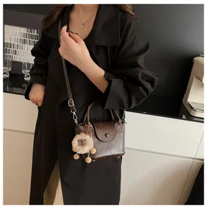 Vintage mini crossbody bag for women, retro chic leather handbag with cute plush charm.