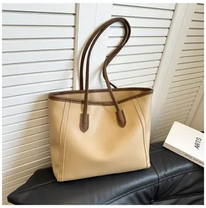 Close-up detail of the stylish contrast color tote bag with sturdy brown handles and spacious interior.