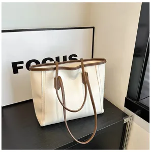 Detailed view of white tote bag with brown trim, stylish casual shoulder bag for daily use.
