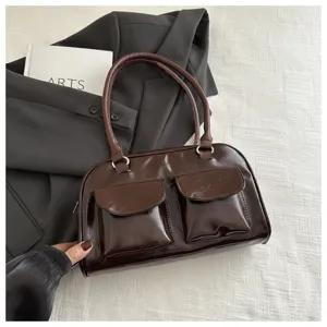 Dark brown patent leather handbag detail, front double pockets, retro fashion boston bag closeup