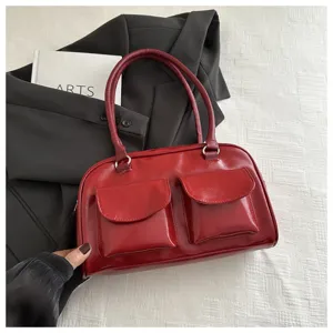 Red glossy leather shoulder handbag featuring dual front flap pockets and vintage style.