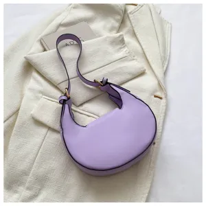 Close-up of the stylish light purple crescent shoulder bag beautifully displayed on white jacket.