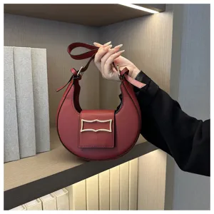 Close-up detail of the red crescent hobo bag showcasing its smooth leather texture and clasp.
