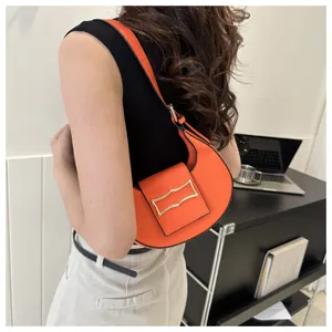Stylish orange crescent shoulder bag for women, trendy underarm purse with metal clasp.