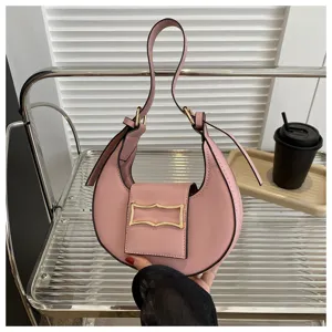 Detailed close-up of a pink crescent underarm bag showing metal buckle and smooth PU leather texture.