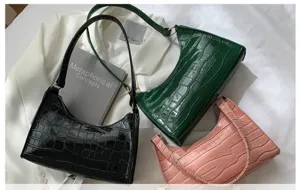 Detailed view of fashionable women's crocodile pattern shoulder baguette bags in chic colors.