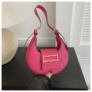 Pink crescent underarm bag detail view showing stylish metallic buckle and smooth leather finish.