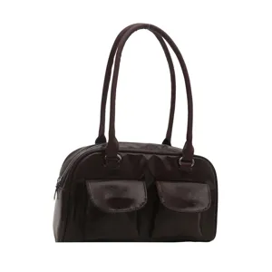 Detail shot of the vintage brown patent leather handbag showing dual straps and front pockets.
