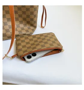 Detail view of brown checkerboard tote bag with matching pouch and phone inside, premium style.