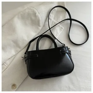 Classic black faux leather handbag with top handle and crossbody strap, elegant minimalist design.