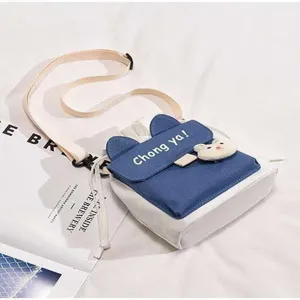 Cute Japanese canvas crossbody bag for girls, blue and white cat ear design with plush decor.