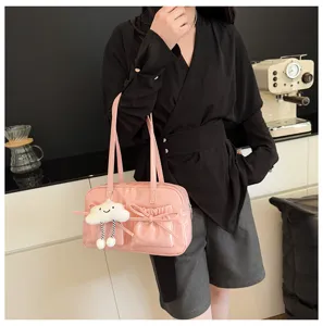 Pink patent leather bowling shoulder bag with bow pocket and cute plush cloud pendant detail.
