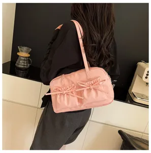 Pink glossy bowling shoulder bag with cute bow pockets, stylish underarm tote for women.