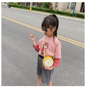 Cute daisy round toddler crossbody bag detail view, yellow PU children handbag in outdoor scene.