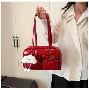 Detail view of red patent leather bowling bag with cute bows and plush cloud charm accessory.