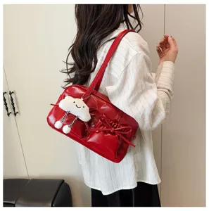 Detail view of red patent leather shoulder bowling bag featuring cute cloud charm bow pocket.