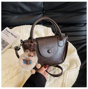 Stylish retro brown leather handbag for women, versatile shoulder bag with cute plush bear pendant.