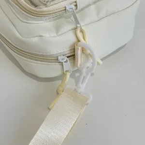 White canvas ita bag detail shot showing zipper and white plastic clasp hardware.