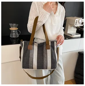 Detail view of the black and white striped canvas tote bag with brown straps, stylish and practical.
