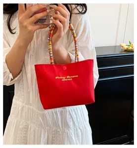 Sac à main chic en toile rouge avec poignée de perles colorées, petit sac élégant été.