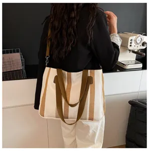 Detailed view of women's striped canvas tote bag with comfortable shoulder strap and handles.