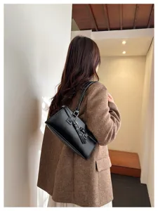 Detailed view of the vintage black leather shoulder bag, showcasing its elegant strap and buckle.