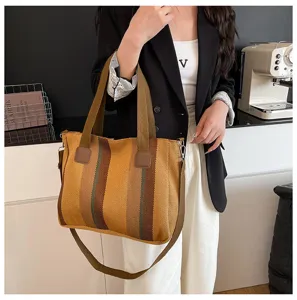 Detailed view of the striped canvas tote bag with shoulder strap in stylish yellow and brown tones.