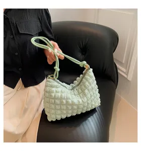 Detail view of a light green ruched cloud shoulder bag, stylish and trendy design.