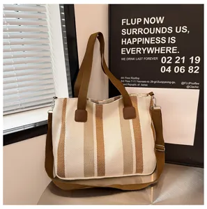 Detailed view of the striped canvas tote bag with brown straps, perfect for daily commute.