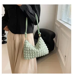 Detailed view of trendy pleated cloud shoulder bag in light green, fashionable and chic style.