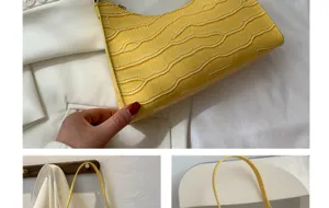 Detail view of stylish yellow crocodile pattern shoulder bag for women, minimalist baguette design.