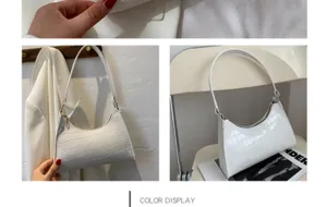 Detailed shot of white crocodile pattern shoulder baguette bag with gold zipper hardware.