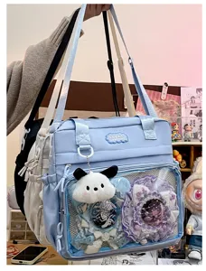 Detail view of Japanese style ita bag with clear pocket, pins and cute plush charm display.