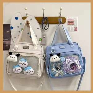 Close-up of clear ita shoulder bags featuring transparent windows and cute plush charms.