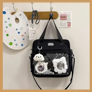 Japanese style black ita bag with clear window, cute plush charm and anime badges.