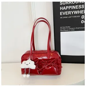 Detailed view of the red glossy bowling shoulder bag featuring chic bows and a cute cloud charm.