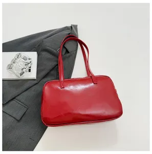 Red leather bowling shoulder bag detail shot, elegant underarm tote bag for women.
