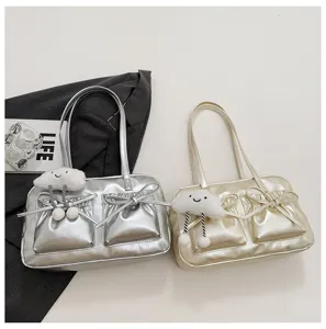 Metallic shoulder bag detail showing dual front pockets, cute cloud plush pendant and bows.