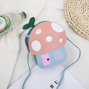 Vista de detalle del bonito bolso bandolera infantil con forma de seta rosa y hoja verde.