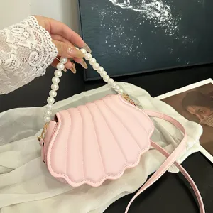 Pink shell crossbody bag for women, trendy pearl handle shoulder bag, stylish summer design.
