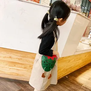 Kids mini crossbody bag with cute strawberry shape and fun dangling legs for daily style.