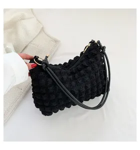 Detailed view of the black textured crinkle shoulder bag, highlighting soft bubble fabric.