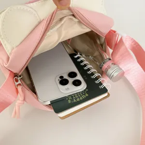 Cute pink canvas shoulder bag interior detail showing spacious capacity for phone and items.