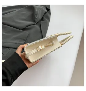 Vue détaillée d'un mini sac à main en tweed blanc avec anses tressées et détails dorés.