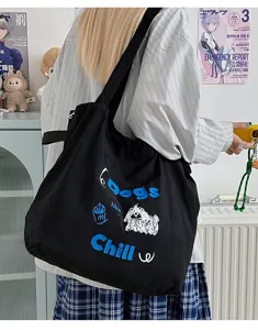 Detail view of black canvas tote bag with cute dog graphic embroidery and casual style.