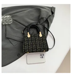 Sac bandoulière en tweed élégant pour femme, design chic à carreaux noir et or avec poignée.