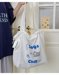 Detail view of casual white canvas tote bag with cute dog graphic and drawstring design.